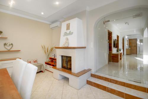 a living room with a fireplace in the middle at Villa Relax Vendégház in Gárdony