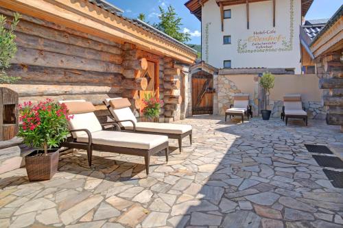 a patio with benches and chairs in front of a building at Ferienhotel Ödenhof in Baiersbronn