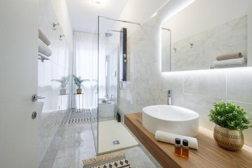 a white bathroom with a sink and a shower at Padova Lux Station in Padova