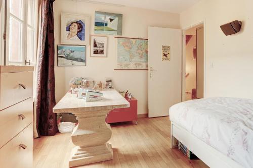 une chambre avec un lit et une table dedans dans l'établissement La Pompadour- Versailles, à Versailles