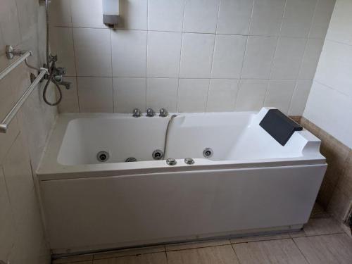 a large white bath tub in a bathroom at Beautiful Home In Secure Township in Accra