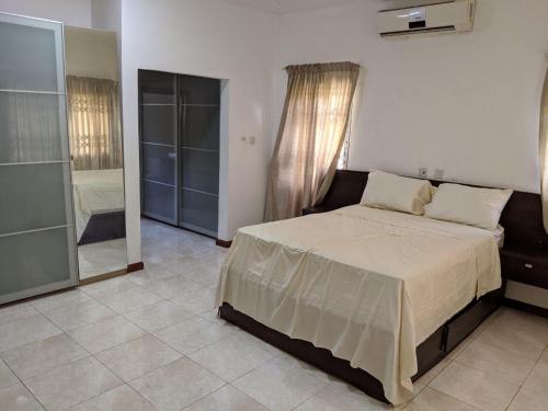 a bedroom with a large bed and a bathroom at Beautiful Home In Secure Township in Accra