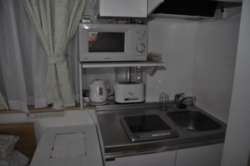 a kitchen with a sink and a microwave at Sunny moe oo in Tokyo