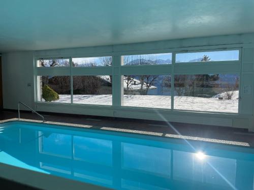 a swimming pool in a house with a window at The Fit’ house in Crans-Montana