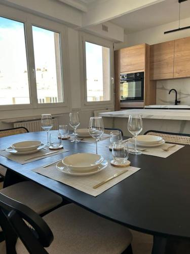 - une table à manger avec des assiettes et des verres à vin dans l'établissement Appartement de charme hyper centre Le Mans, au Mans