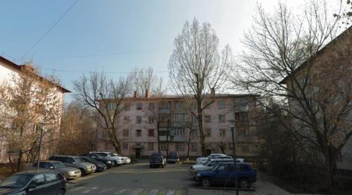 a parking lot with cars parked in front of a building at NBG Flat in Almaty