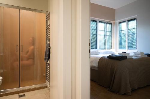 een slaapkamer met een bed en een glazen douche bij Linas Home - Kalamata Mediterranean Villas in Kalamata