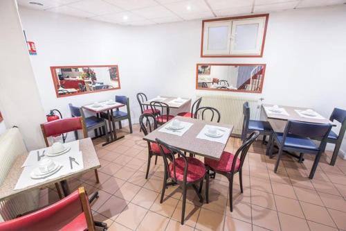 una sala da pranzo con tavoli e sedie in un ristorante di Hipotel Paris Belgrand Mairie du 20ème a Parigi