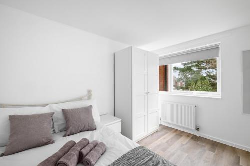 een witte slaapkamer met een bed en een raam bij Spacious Free Parking Contractors and Corporate in Exeter
