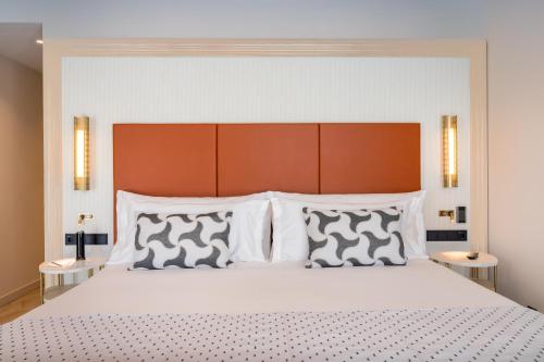 a bedroom with a large bed with white pillows at Barceló Carmen Granada in Granada