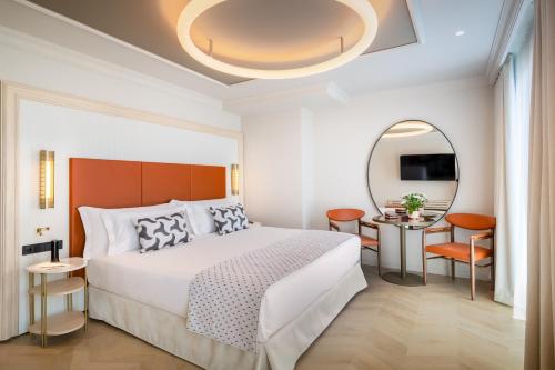 um quarto de hotel com uma cama e um espelho em Barceló Carmen Granada em Granada