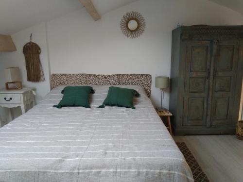 - une chambre avec un grand lit et 2 oreillers verts dans l'établissement Carro duplex les pieds dans l'eau et la tête dans les pins, à Martigues