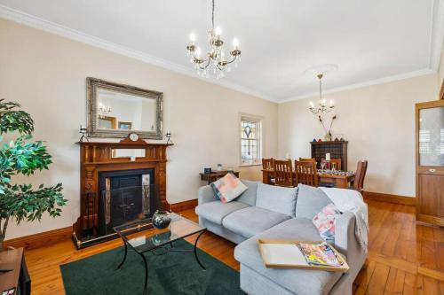 a living room with a couch and a fireplace at Spacious home near Glenelg in South Plympton