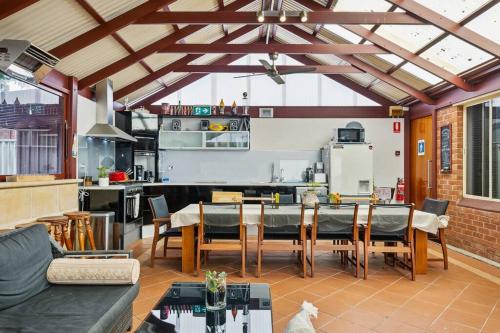 a living room with a table and a kitchen at Spacious home near Glenelg in South Plympton