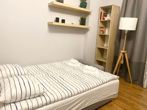 1 dormitorio con 1 cama con sábanas blancas y lámpara en W Sercu Gdańska, en Gdansk