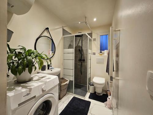 een badkamer met een douche en een wasmachine bij Appartement Proche Aéroport CDG in Vaujours