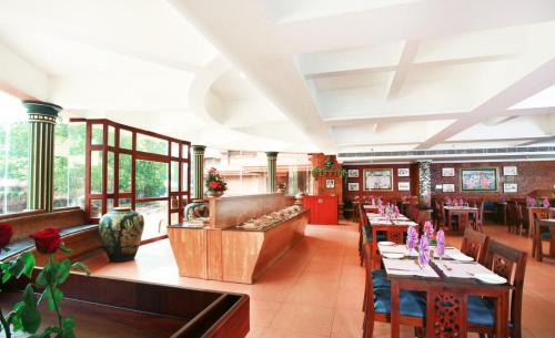 a restaurant with tables and chairs in a room at Krishna Beach Resort in Kannur