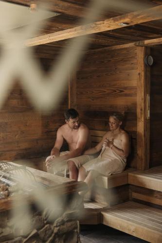 a man and a woman sitting in a sauna at Kaiserlodge in Scheffau am Wilden Kaiser