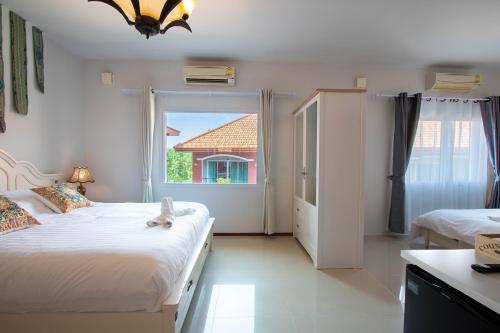 湄平的住宿－Hacienda Resort - Mae Phim，一间卧室设有两张床和窗户。