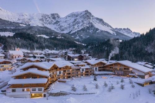 a resort in the snow with mountains in the background at Kaiserlodge in Scheffau am Wilden Kaiser