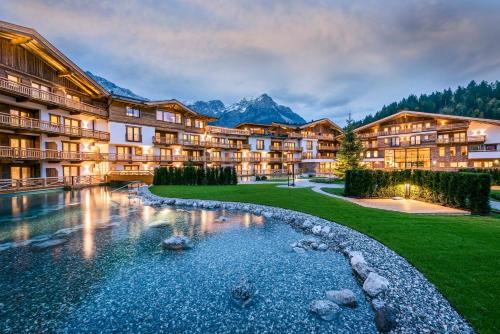 a resort with a pond in the yard at Kaiserlodge in Scheffau am Wilden Kaiser