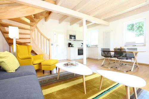 a living room with a couch and a table and chairs at Neu Reet Ferienhaus Svantevit in Lohme