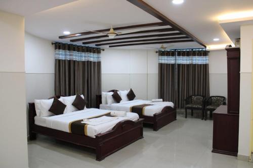 a hotel room with two beds and a television at MALDIVES INN in Bengaluru