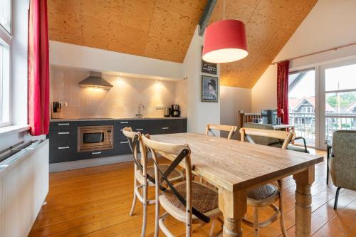 cocina y comedor con mesa de madera y sillas en Summio Havenresort Terherne en Terherne