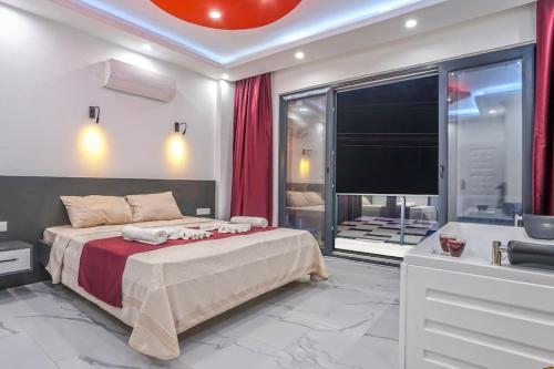 ein Schlafzimmer mit einem Bett und ein Badezimmer mit einer Badewanne in der Unterkunft Villa Hazal 2 / Kalkan in Kaş