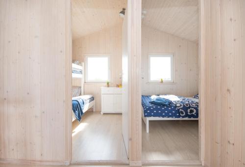 una camera con un letto a castello e due finestre di TURKUSOWE ZACISZE a Kopań