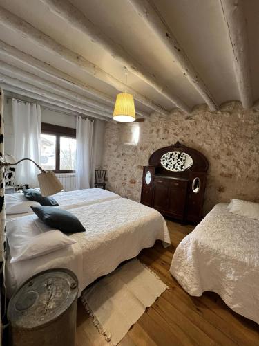 a large bedroom with two beds and a lamp at Casa Rural La Chocolateria in Horche