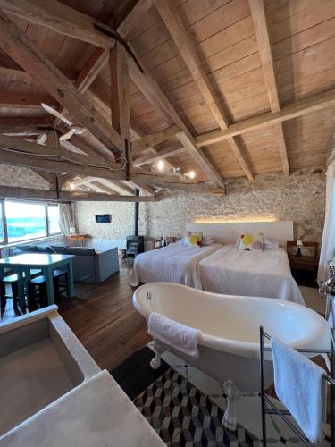 a large room with two beds and a bathtub at Casa Rural La Chocolateria in Horche