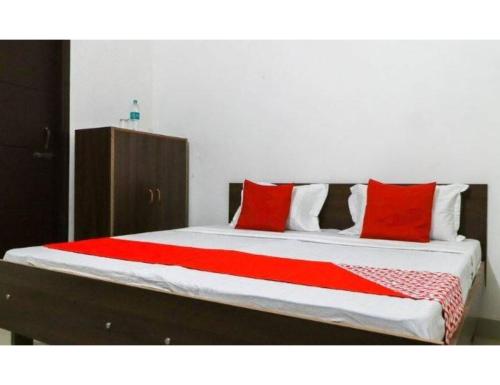 uma cama com almofadas vermelhas num quarto em Verma Ji Hotel, Raman, Punjab 