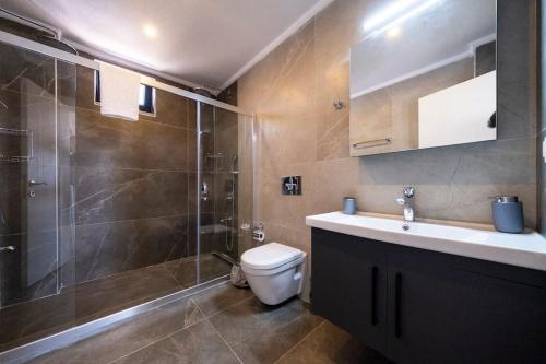 La salle de bains est pourvue de toilettes, d'une douche et d'un lavabo. dans l'établissement Villa Sazak Duo, à Gelemiş
