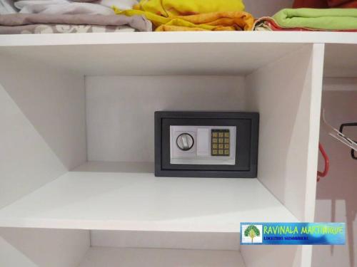 a shelf with a white shelf with a microwave on it at APPARTEMENT COSY TERRASSE VUE MER - TROIS ÎLETS in Les Trois-Îlets