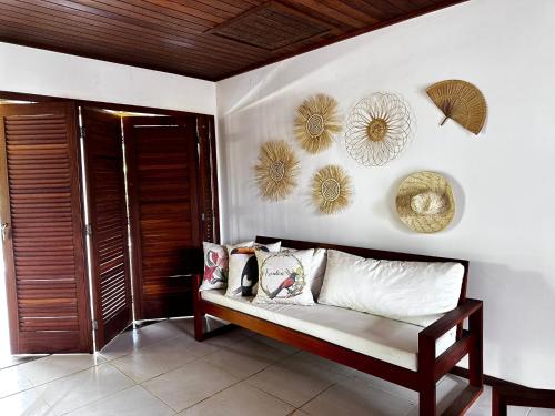 um quarto com um sofá e algumas decorações na parede em Casa Barra Grande em Maraú