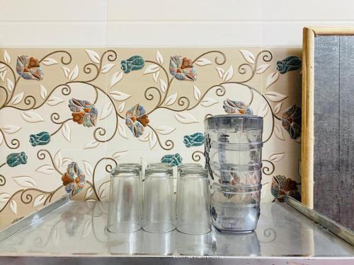 a group of glass jars sitting on a counter with a butterfly wall at Hotel Best Stay By Hariganga Haridwar in Haridwār