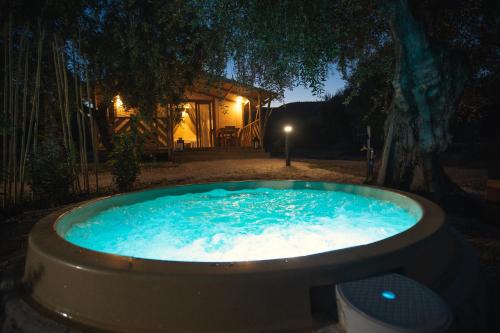 a hot tub in a yard at night at Le Lenze Don Mimì Glamping in Mattinata