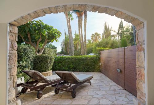 a stone archway with two chairs and a table at Columbia Beach Resort in Pissouri