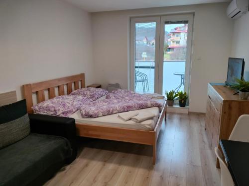 1 dormitorio con cama, sofá y ventana en Apartmán Paula 3, en Podhájska