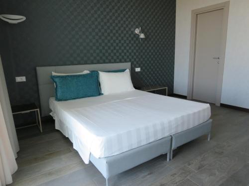 een slaapkamer met een groot wit bed met blauwe kussens bij Hotel Joseph in Marina di Pietrasanta