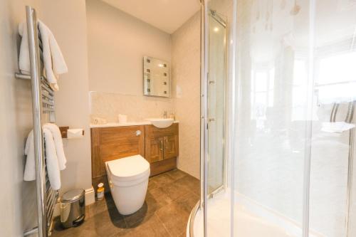 a bathroom with a toilet and a glass shower at Brierholme Guest House in Keswick