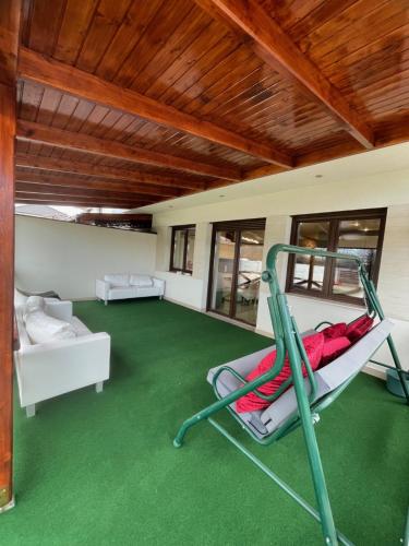 a room with a green carpet and a swing at VRG 1 Exkluzív Apartman in Debrecen