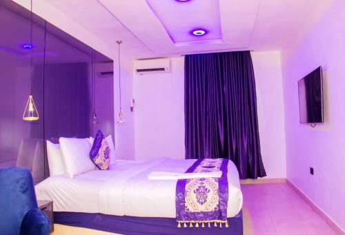 a bedroom with a large bed with purple lighting at Water Ripples Hotel Lekki in Lekki