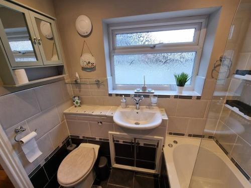 a bathroom with a sink and a toilet and a window at Cosy home in York in York