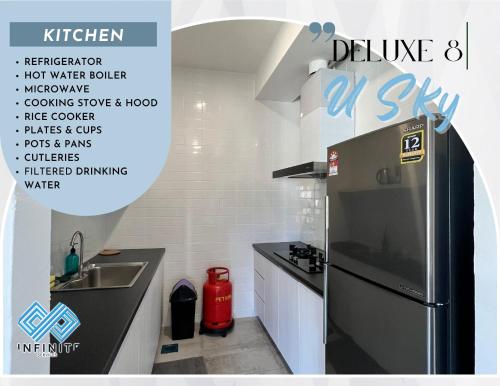 a kitchen with a black refrigerator and a sink at Roxy Sematan Beach Townhouse Deluxe 7 ,8 ,9, 10 ,11 ,12 in Sematan