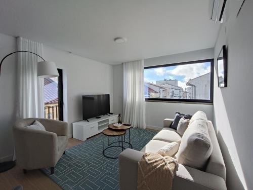 a living room with a couch and a tv at Casa Urban Coastal - City Center in Ponta Delgada