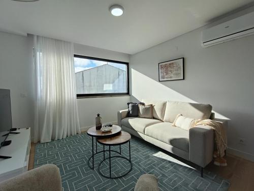 a living room with a couch and a table at Casa Urban Coastal - City Center in Ponta Delgada