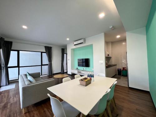 a living room with a table and a couch at Roxy Sematan Beach Townhouse Deluxe 7 ,8 ,9, 10 ,11 ,12 in Sematan