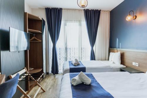 a hotel room with two beds and a flat screen tv at The Rest Port Hotel in Edirne